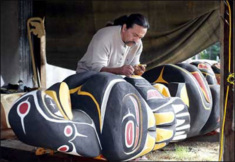 a Coast Salish carver working on a large carving