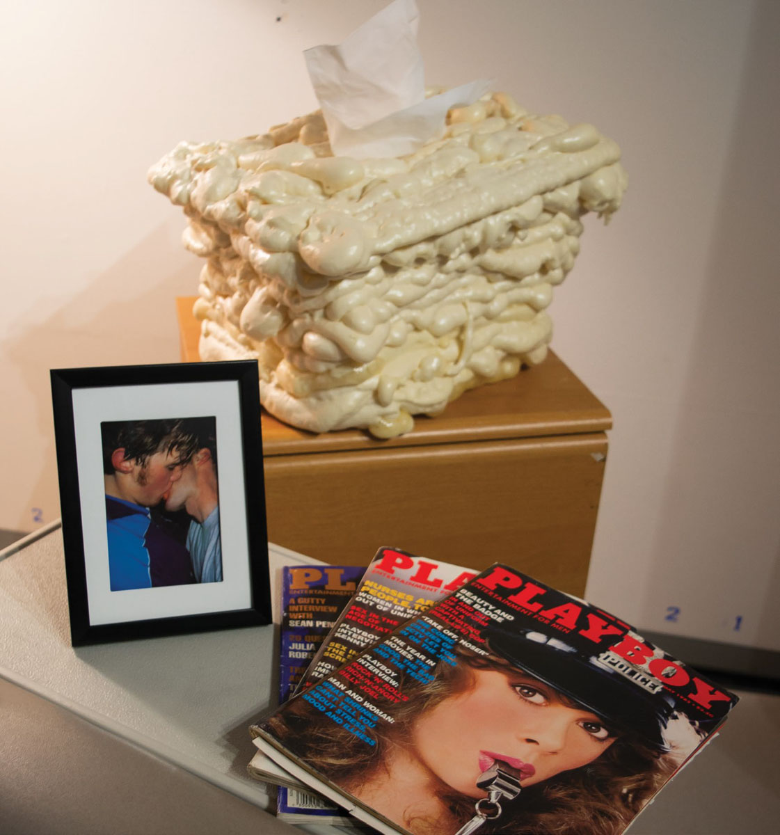 A gloopy tissue box, framed photo, a stack of playboy magazines in the corner of a waiting room