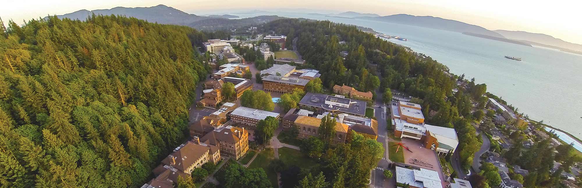aerial view of Western's campus, the forest of Sehome Hill, and Bellingham Bay with islands visible