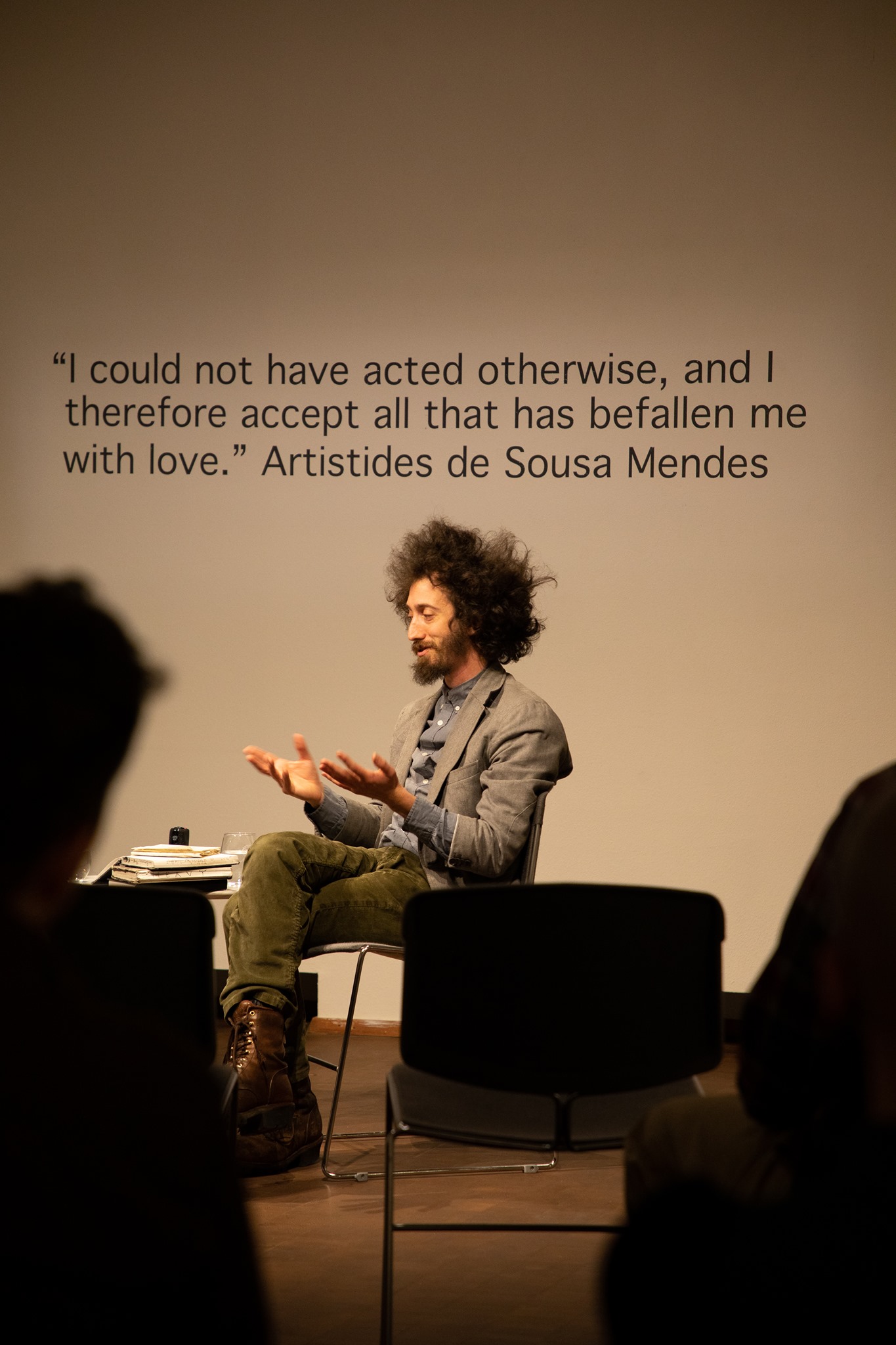 An artist shares their thoughts with a small audience in a gallery setting