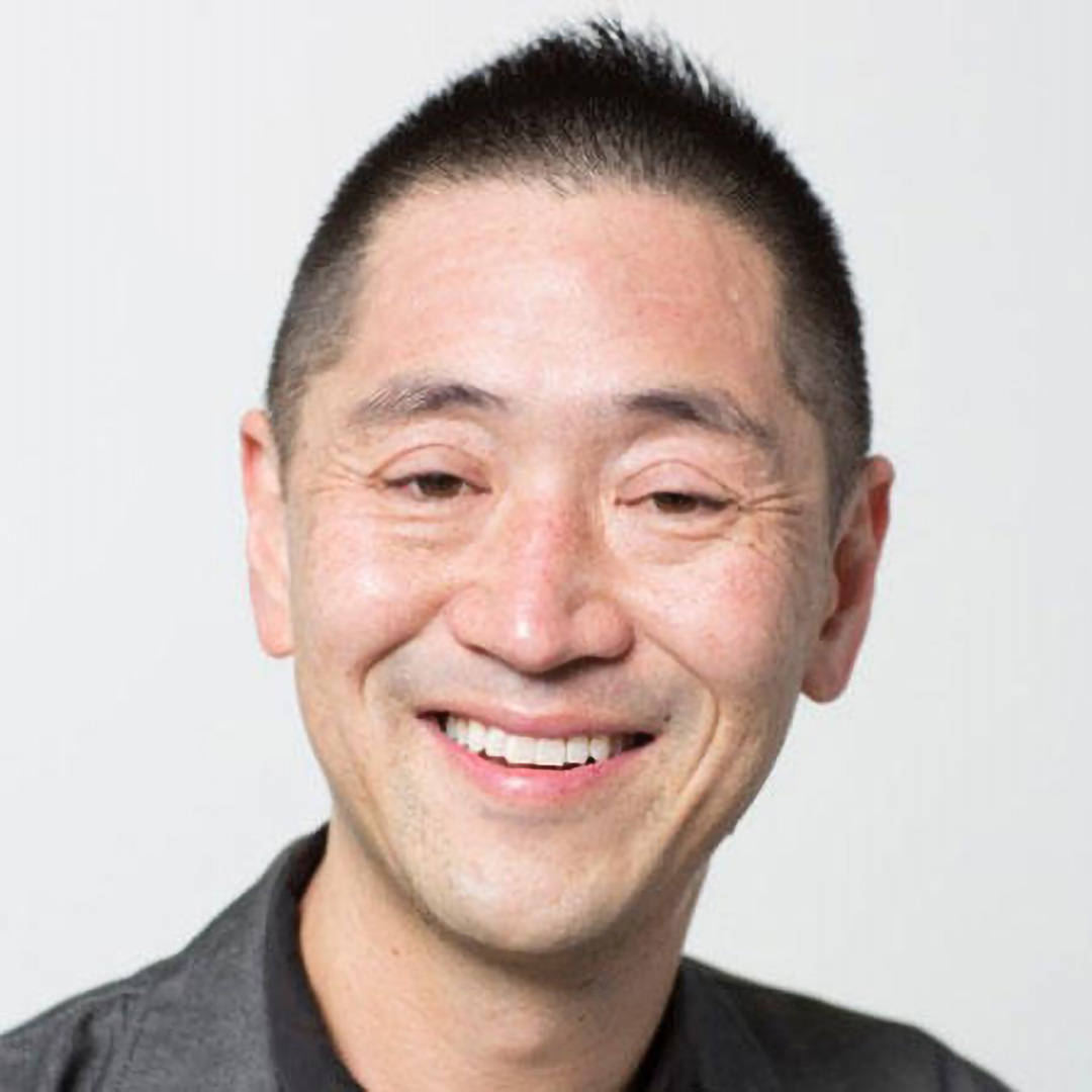 Ken Tadashi Oshima with short hair and a big smile