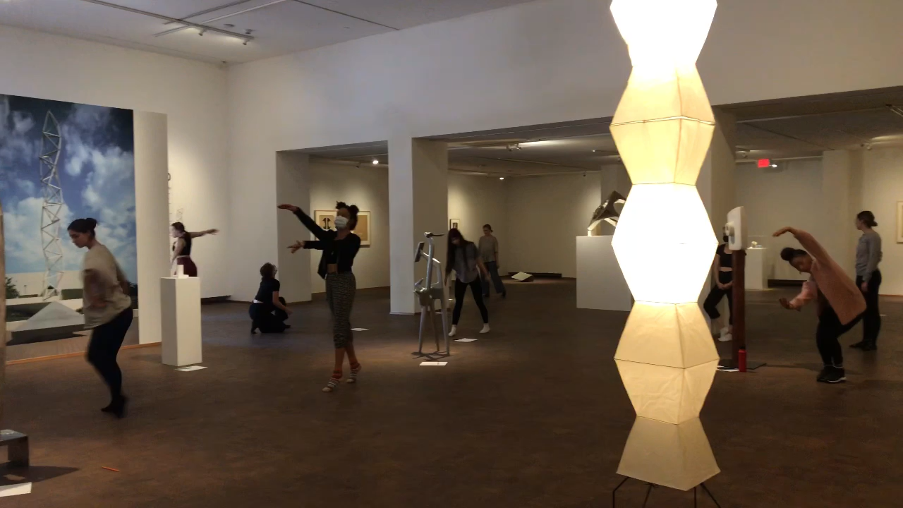 dancers move among modern sculptures and lamps by the artist Isamu Noguchi