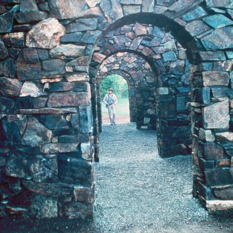 View through multiple archways of Nancy Holt's sculpture Stone Enclosure: Rock Rings. Full description in body text.