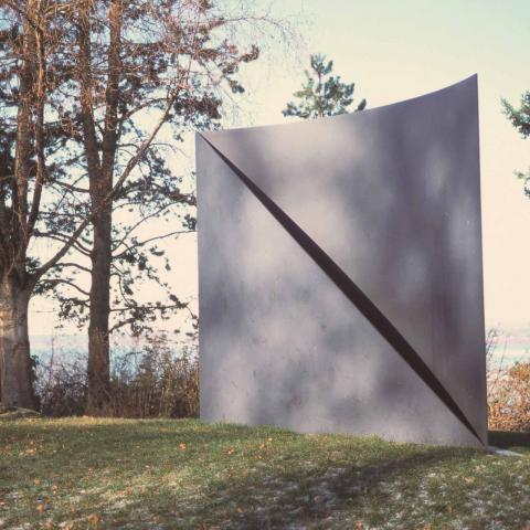 Robert Maki's sculpture Curve/Diagonal flanked by trees. Full description in body text.