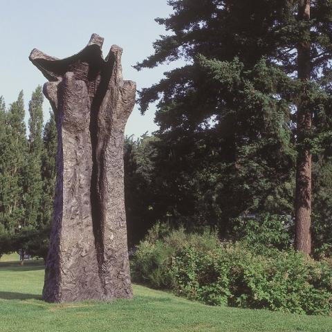Magdalena Abakanowicz's sculpture Manus, viewed on a lawn in front of trees. Full description in body text.