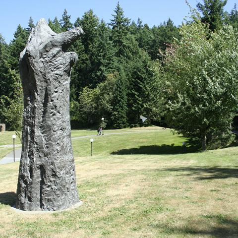Magdalena Abakanowicz's sculpture Manus in a hilly field with paved walkways. Full description in body text.