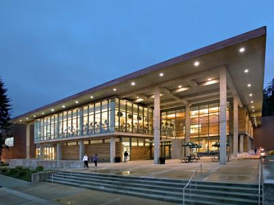 exterior of Wade King Recreation Center, a moden building. The inside it lit up, outside it is dusk.