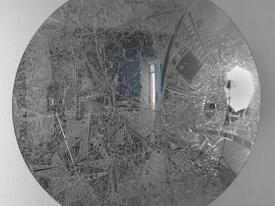 a crackled reflective convex graphite roundel with indistinct images