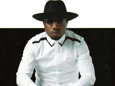 Knowledge Bennett wearing a black hat, sunglasses, and white collared shirt
