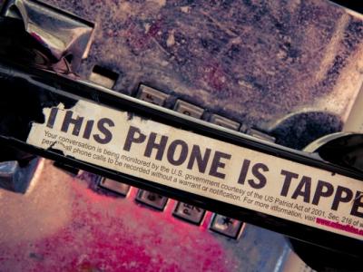 old telephone handset with a sticker that reads "this phone is tapped"