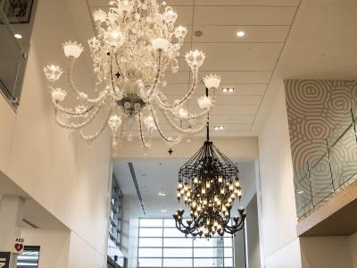 two chandelier sculptures hang above people inside the Viking Union common area