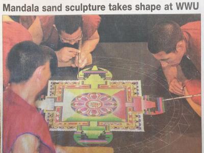 Three Tibetan Buddhist monks create a sand painting, or mandala