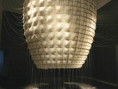 an inverted cylindrical object hangs from the ceiling and tapers as it nears the floor