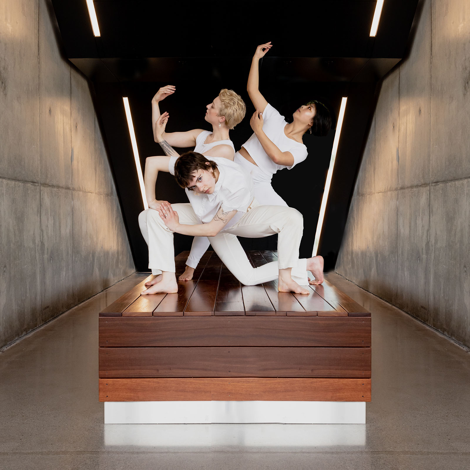 Three dancers in an angular, sculptural pose
